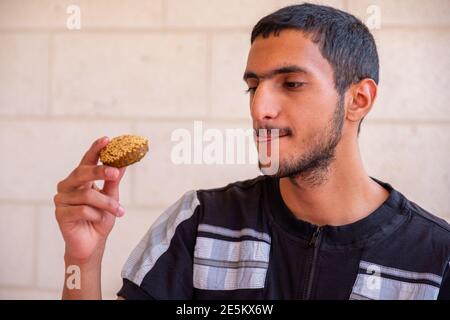 L'homme musulman mange du falafel et profite de son temps Banque D'Images