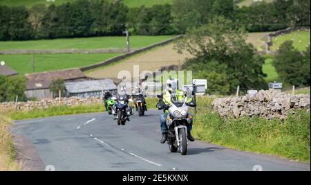 Motocyclistes sur une route rurale à Swaledale près de Muker, se dirigeant sur le col des Buttertubs vers Hawes, Wensleydale. Parc national de Yorkshire Dales, U Banque D'Images