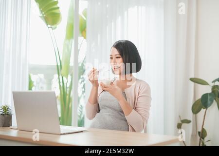 Portrait d'une jolie femme vietnamienne mangeant du yaourt probiotique Banque D'Images