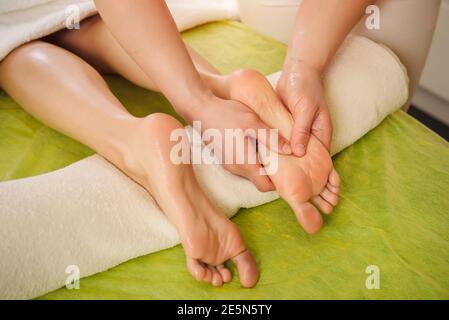 Massage traditionnel des pieds. Belle femme profitant d'un soin dans un centre de spa Banque D'Images