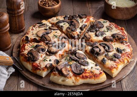 Tranches de pizza aux champignons et au fromage avec du thym frais une pierre à pâtisserie Banque D'Images