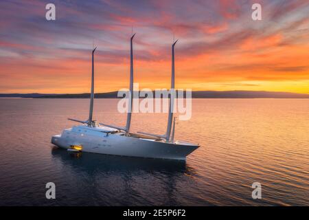 Vue aérienne du yacht de luxe dans la mer bleue au coucher du soleil en été Banque D'Images