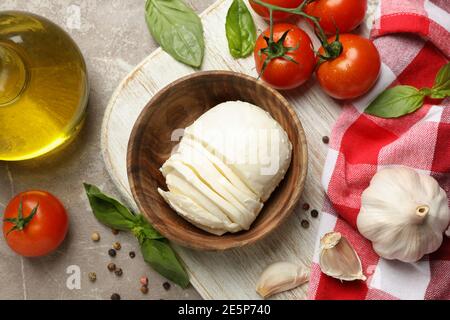 Concept de repas savoureux avec mozzarella et ingrédients à bord sur table texturée grise Banque D'Images