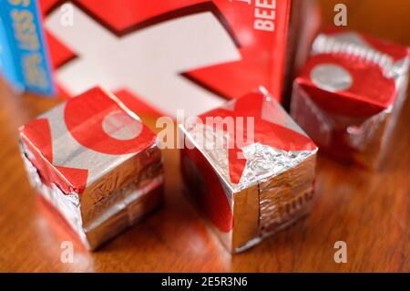 cubes d'oxo emballés dans un emballage en feuille d'argent sur une table en bois haut Banque D'Images
