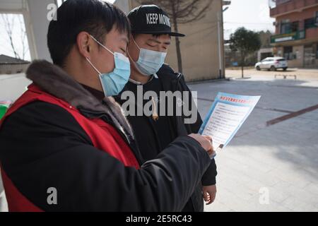 (210128) -- WUHAN, le 28 janvier 2021 (Xinhua) -- UN membre du comité du village insiste sur les exigences de prévention des épidémies à Gao Li, village de Shuikousi, ville de Caijiazha, district de Hangpi, ville de Wuhan, province de Hubei en Chine centrale, le 28 janvier 2021. Le premier jour de la course de voyage du Festival de printemps en 2021, Gao Li, un travailleur migrant « de l'après-90 » à Shanghai, a emballé ses bagages et a mis le pied sur le chemin du retour à sa ville natale de Huangpi, Wuhan de Chine centrale pour le Festival de printemps. Avant de s'enregistrer, il a fumiré pour le rapport négatif de tests d'acide nucléique dans son sac. Rien ne pouvait Banque D'Images