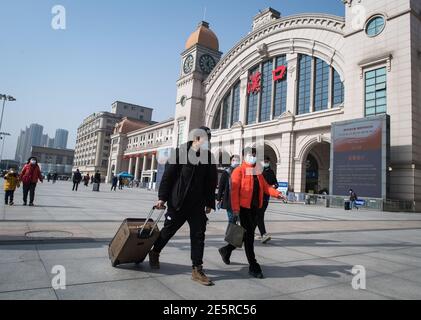 (210128) -- WUHAN, le 28 janvier 2021 (Xinhua) -- Gao Li et sa tante qui vient le chercher se préparent à rentrer à l'extérieur de la gare de Hankou à Wuhan, dans la province de Hubei en Chine centrale, le 28 janvier 2021. Le premier jour de la course de voyage du Festival de printemps en 2021, Gao Li, un travailleur migrant « de l'après-90 » à Shanghai, a emballé ses bagages et a mis le pied sur le chemin du retour à sa ville natale de Huangpi, Wuhan de Chine centrale pour le Festival de printemps. Avant de s'enregistrer, il a fumiré pour le rapport négatif de tests d'acide nucléique dans son sac. Rien ne pourrait être plus important que ce bagage. Deux Banque D'Images