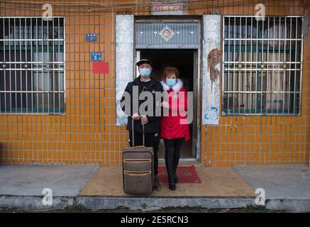 (210128) -- WUHAN, le 28 janvier 2021 (Xinhua) -- Gao Li pose pour une photo de groupe avec sa mère devant sa maison dans le village de Shuikousi de Caijiazha, district de Hangpi de Wuhan, province de Hubei en Chine centrale, le 28 janvier 2021. Le premier jour de la course de voyage du Festival de printemps en 2021, Gao Li, un travailleur migrant « de l'après-90 » à Shanghai, a emballé ses bagages et a mis le pied sur le chemin du retour à sa ville natale de Huangpi, Wuhan de Chine centrale pour le Festival de printemps. Avant de s'enregistrer, il a fumiré pour le rapport négatif de tests d'acide nucléique dans son sac. Rien ne pourrait être plus important que cela Banque D'Images