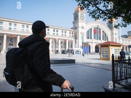 (210128) -- WUHAN, le 28 janvier 2021 (Xinhua) -- Gao Li attend que sa tante le vienne le chercher à l'extérieur de la gare de Hankou à Wuhan, dans la province de Hubei, dans le centre de la Chine, le 28 janvier 2021. Le premier jour de la course de voyage du Festival de printemps en 2021, Gao Li, un travailleur migrant « de l'après-90 » à Shanghai, a emballé ses bagages et a mis le pied sur le chemin du retour à sa ville natale de Huangpi, Wuhan de Chine centrale pour le Festival de printemps. Avant de s'enregistrer, il a fumiré pour le rapport négatif de tests d'acide nucléique dans son sac. Rien ne pourrait être plus important que ce bagage. Il y a deux jours, Shanghai Medical Banque D'Images