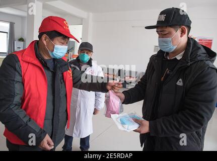 (210128) -- WUHAN, le 28 janvier 2021 (Xinhua) -- UN membre du personnel du comité du village distribue Gao Li avec des fournitures anti-épidémiques au village de Shuikousi de la ville de Caijiazha, district de Hangpi de la ville de Wuhan, province de Hubei en Chine centrale, le 28 janvier 2021. Le premier jour de la course de voyage du Festival de printemps en 2021, Gao Li, un travailleur migrant « de l'après-90 » à Shanghai, a emballé ses bagages et a mis le pied sur le chemin du retour à sa ville natale de Huangpi, Wuhan de Chine centrale pour le Festival de printemps. Avant de s'enregistrer, il a fumiré pour le rapport négatif de tests d'acide nucléique dans son sac. Rien ne pourrait être plus moi Banque D'Images