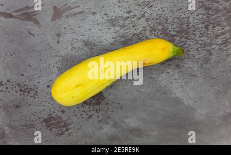 Vue de dessus d'un seul jardin de la maison de courge jaune d'été sur un fond gris marbré. Banque D'Images