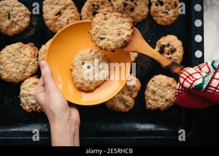 Femme prend de délicieux biscuits faits maison au four. Gros plan sur un doux désert sur une casserole sombre Banque D'Images