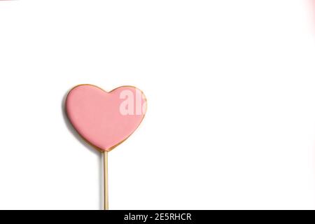 Coeur doux sur un bâton sur fond blanc. Petits gâteaux roses pour la Saint-Valentin Banque D'Images