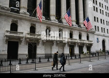 Les personnes portant un masque protecteur passent devant la Bourse de New York (NYSE) à Wall Street le 27 janvier 2021 à New York. Banque D'Images