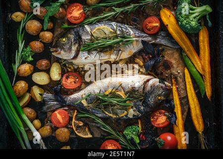 Poisson dorado grillé aux herbes aromatiques, aux épices et aux légumes. Alimentation saine en mer, vue du dessus Banque D'Images