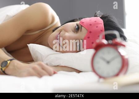Jeune femme couché au lit portant un masque de sommeil Banque D'Images