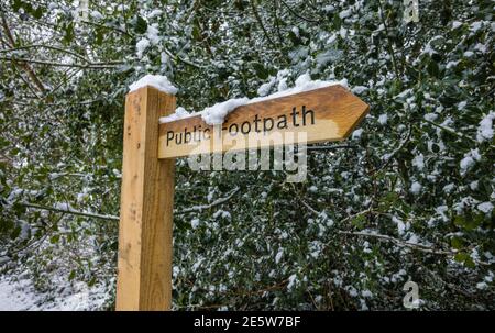 Nouveau panneau de signalisation de chemin de pied public en bois avec de la neige après une forte chute de neige à Woking, Surrey, dans le sud-est de l'Angleterre Banque D'Images