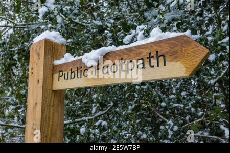 Nouveau panneau de signalisation de chemin de pied public en bois avec de la neige après une forte chute de neige à Woking, Surrey, dans le sud-est de l'Angleterre Banque D'Images