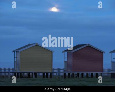 Leysdown, Kent, Royaume-Uni. 28 janvier 2021. Météo au Royaume-Uni : la pleine lune du loup s'élève au-dessus des cabanes de plage à Leydown, dans le Kent - la première pleine lune de 2021. Crédit : James Bell/Alay Live News Banque D'Images