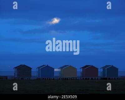 Leysdown, Kent, Royaume-Uni. 28 janvier 2021. Météo au Royaume-Uni : la pleine lune du loup s'élève au-dessus des cabanes de plage à Leydown, dans le Kent - la première pleine lune de 2021. Crédit : James Bell/Alay Live News Banque D'Images