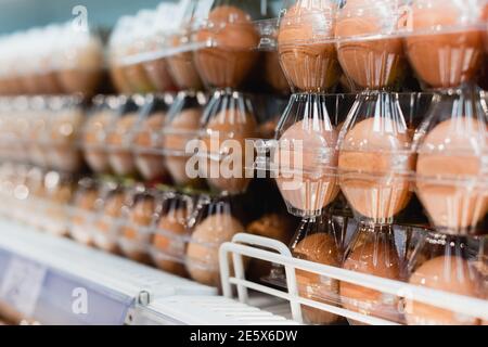 Vue rapprochée des œufs en paquets dans le supermarché sur arrière-plan flou Banque D'Images