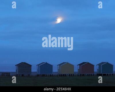 Leysdown, Kent, Royaume-Uni. 28 janvier 2021. Météo au Royaume-Uni : la pleine lune du loup s'élève au-dessus des cabanes de plage à Leydown, dans le Kent - la première pleine lune de 2021. Crédit : James Bell/Alay Live News Banque D'Images