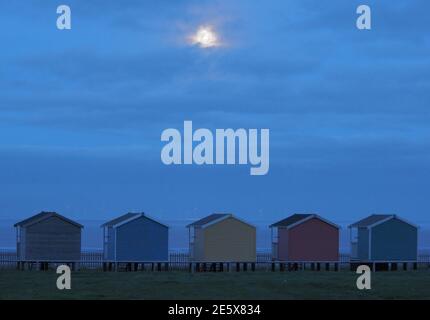 Leysdown, Kent, Royaume-Uni. 28 janvier 2021. Météo au Royaume-Uni : la pleine lune du loup s'élève au-dessus des cabanes de plage à Leydown, dans le Kent - la première pleine lune de 2021. Crédit : James Bell/Alay Live News Banque D'Images