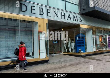 Londres, Royaume-Uni. 28 janvier 2021. Des mannequins se tiennent à l'entrée tandis qu'une femme passe devant l'extérieur du grand magasin Debenhams d'Oxford Street, la maison traditionnelle de la vente au détail dans le West End. Les fenêtres et la surface de vente du magasin ont déjà été vidée du stock. Le détaillant en ligne Boohoo a récemment acheté la marque Debenhams, tous les magasins fermera et 12,000 employés perdront leur emploi. Credit: Stephen Chung / Alamy Live News Banque D'Images