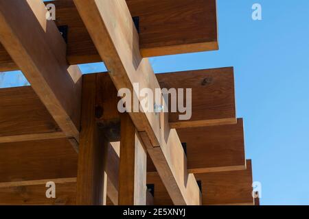 Composition géométrique abstraite de planches de bois marron contre un ciel bleu. Fragment d'un belvédère extérieur. Mise au point sélective. Banque D'Images