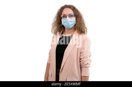 Jeune femme en costume portant un masque et des lunettes isolées sur un blanc. Prévention du coronavirus ou du covid 19. Banque D'Images