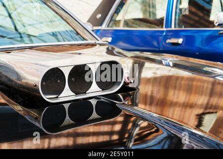 L'accélérateur sur le capot du muscle car gros plan. Pelle à capot à trois sections au milieu du capot avant d'une vieille voiture classique américaine Banque D'Images
