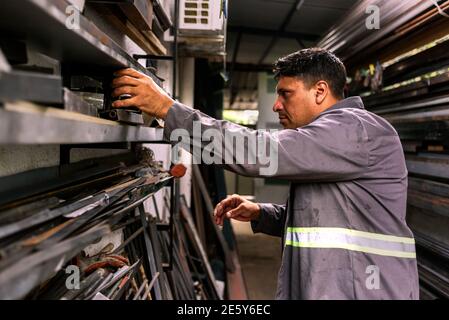 Photo de l'homme concentré travaillant dans un atelier de forgeron. Banque D'Images