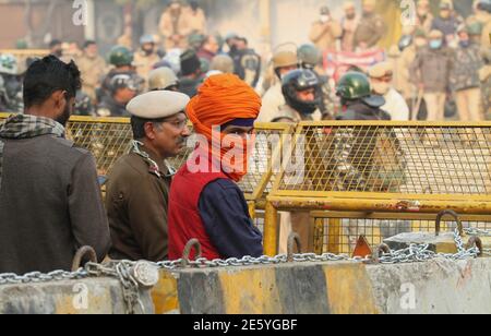 Un agriculteur sikh regarde alors que les forces paramilitaires indiennes sont déployées à la frontière de Singhu (Delhi - frontière de Haryana) pendant la manifestation.les agriculteurs protestent contre les nouvelles lois agricoles exigeant une définition légale de MSP (minimum support Price). La tension a augmenté après que les forces de sécurité se sont élevées à la frontière de Singhu et Ghazpur, mais les dirigeants des agriculteurs ont refusé de quitter le site de la manifestation. Banque D'Images