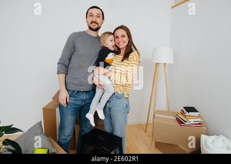 La famille a emménagé dans une nouvelle maison, image sur fond de boîtes et de murs blancs Banque D'Images