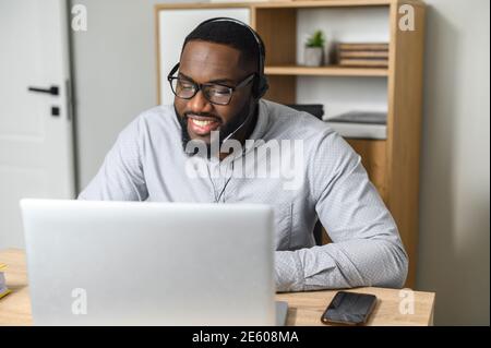 Un jeune travailleur de bureau afro-américain enthousiaste qui travaille sur des lunettes en direct et en streaming. Étudiants en formation professionnelle à la conférence en ligne Banque D'Images