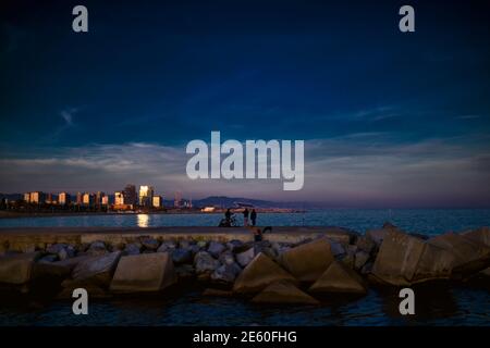 Barcelone, Espagne. 28 janvier 2021. Les navetteurs pêchent dans un brise-lames sur le front de mer de Barcelone au coucher du soleil Credit: Matthias Oesterle/Alamy Live News Banque D'Images