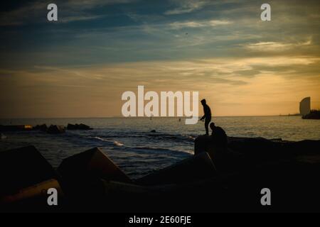 Barcelone, Espagne. 28 janvier 2021. Les navetteurs pêchent dans un brise-lames sur le front de mer de Barcelone au coucher du soleil Credit: Matthias Oesterle/Alamy Live News Banque D'Images