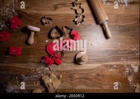 Vue de dessus des tables en bois saupoudrées de farine pleines de emporte-pièces de différentes formes et de rouleau de pâte. Banque D'Images