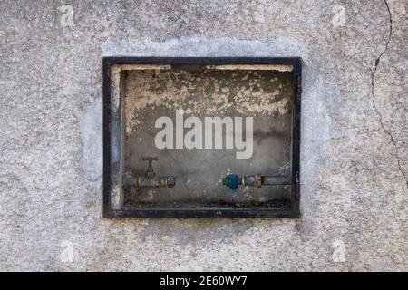 Tuyau d'alimentation en eau domestique déconnecté avec robinet et eau manquante compteur installé sur un mur en béton grundy externe Banque D'Images