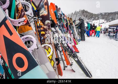 Big Sky, MT, US-Feb 7 2020: De nombreuses paires de skis sont pendu sur un rack dans une station de ski en hiver. Banque D'Images