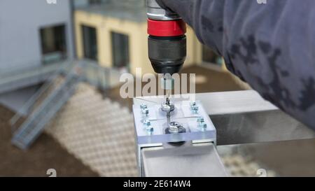 Gros plan des trous de perçage à l'aide d'une douille de gabarit pour un guidage précis du foret hélicoïdal. Gabarit d'alésage en acrylique et en aluminium. Main courante en acier inoxydable. Banque D'Images