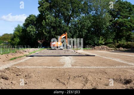 Excavatrice travaillant à la construction d'un stade d'équitation Banque D'Images