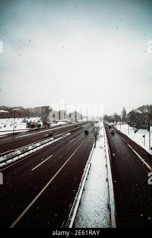 Autoroute photographiée depuis un pont, paysage urbain d'hiver avec de la neige tombant sur l'autoroute Banque D'Images