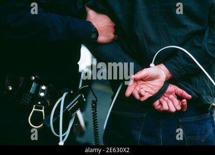 San Francisco, Californie, États-Unis. Un policier de San Francisco a arrêté un manifestant lors d'une grande manifestation en 1989. L'agent a utilisé des attaches autobloquantes en plastique lourd sur les poignets du manifestant pendant l'arrestation. Banque D'Images