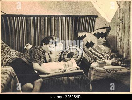 NEURUPPIN, ALLEMAGNE DE L'EST - VERS 1960s: Photo rétro montre maman heureuse avec bébé enfant. Les années soixante et l'oreiller tricoté dans le bloc socialiste. 1960s Banque D'Images