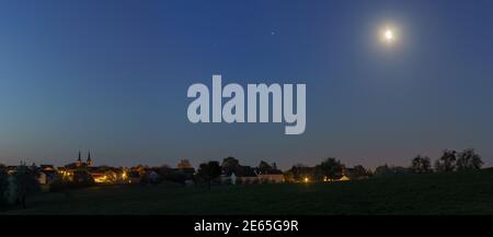 panorama du croissant de lune et des planètes mars, jupiter et saturne montantes au-dessus du village allemand dans l'eifel à l'aube Banque D'Images