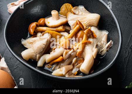 Champignons sauvages Boletus edulis et cachez les boletus dans un jeu de bocal, sur fond noir Banque D'Images