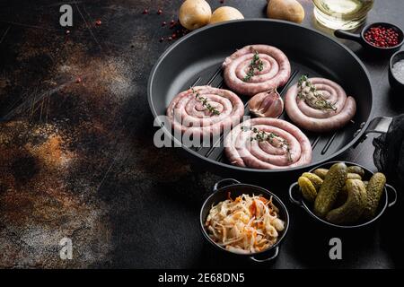 Saucisses traditionnelles allemandes avec purée de pommes de terre et de choucroute dans une poêle en fonte, sur fond rustique foncé, vue de dessus plat, avec espace f Banque D'Images