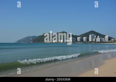 les vagues blanches courent sur la plage de sable jaune sous le soleil jour Banque D'Images