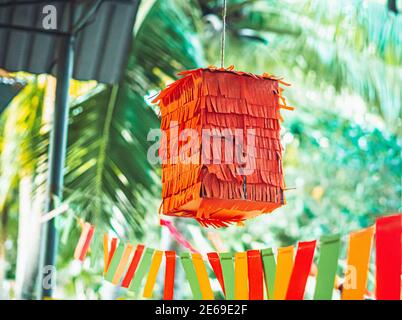 En forme de carré pour enfants fête mexicaine orange pinata suspendu en plein air utilisé pour s'amuser dans posadas et vacances d'anniversaire, coloré jaune rouge décoration verte Banque D'Images