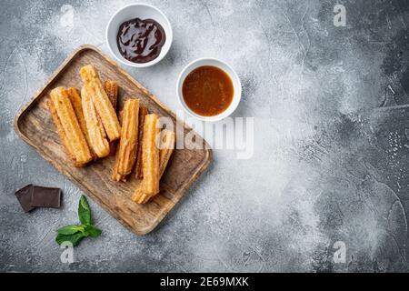 Churos à la sauce au sucre et au chocolat, sur fond gris, vue de dessus plat avec espace pour le texte, copyspace Banque D'Images